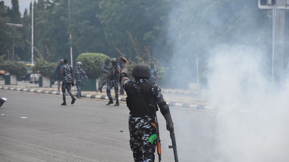 ABUJA, NIGERIA - AUGUST 01: Nigerian police officers and military members intervene with tear gas canisters as hundreds of Nigerian citizens holding Nigerian flags, banners and placards gather to march through the streets during a demonstration over high cost of living and removal of fuel subsidies in Abuja, Nigeria on August 01, 2024. (Photo by Adam Abu-bashal/Anadolu via Getty Images)