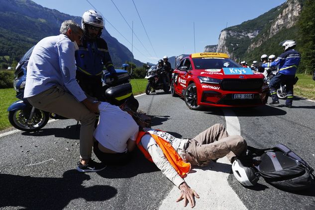 Służby usuwające demonstrantów z trasy Tour de France (PAP/EPA)