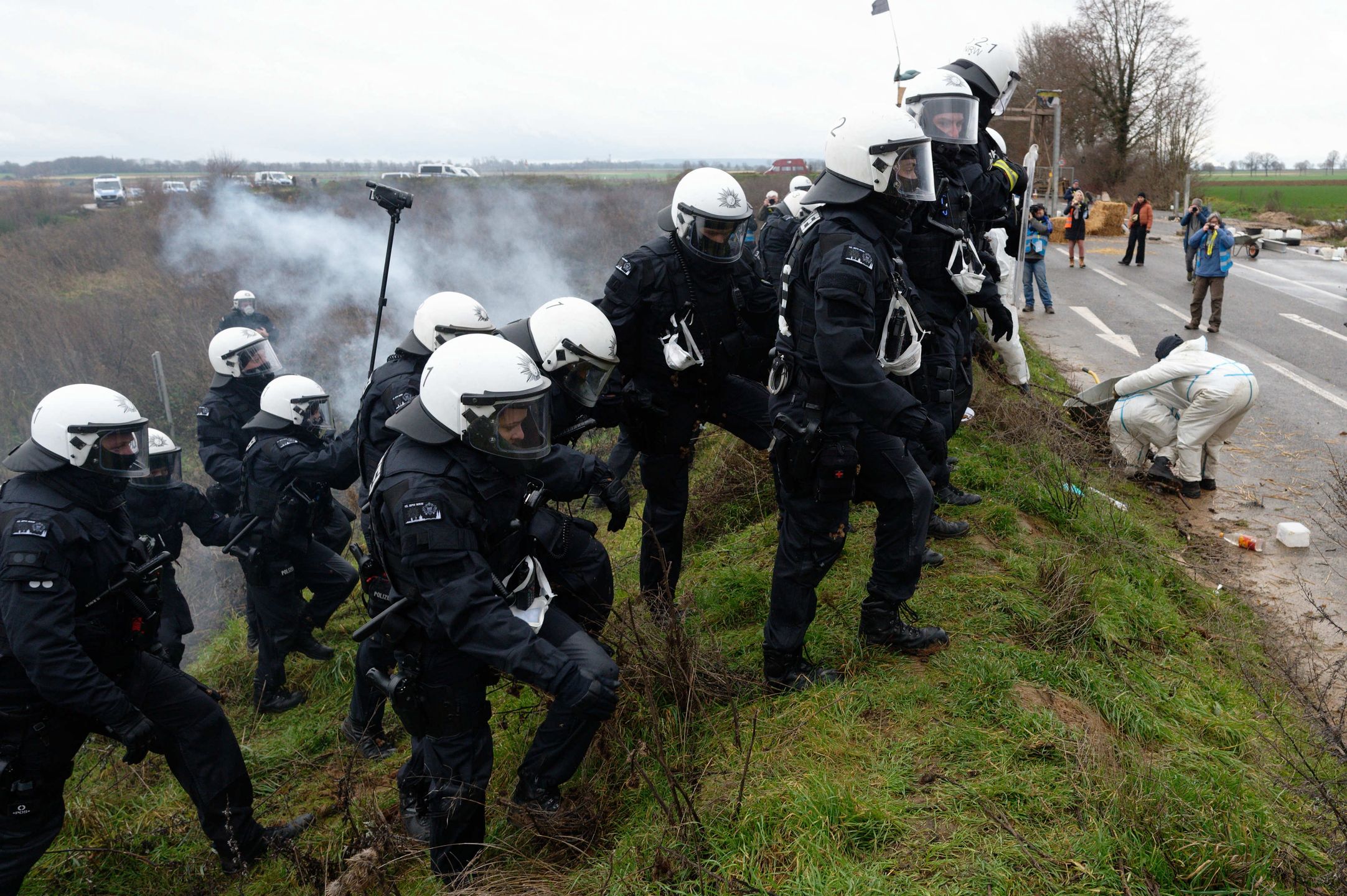 Activists block road to Luetzerath village set to be demolished
02 January 2023, North Rhine-Westphalia, Luetzerath: Police officers (L) push activists off a road leading to a road to the village of Luetzerath. German climate activists positioned themselves on Monday behind a burning barricade to stop construction workers reaching a village earmarked for demolition for mining works. Photo: Henning Kaiser/dpa 
Dostawca: PAP/DPA.
Henning Kaiser