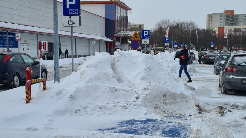 Śnieg z parkingu przed marketem Auchan spychany jest na miejsca postojowe dla niepełnosprawnych | fot. czytelnik Robert
