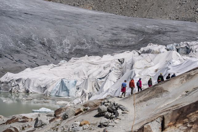 Rhone Glacier covered in blanketsepa10068576 People visit the Rhone Glacier covered in blankets above Gletsch near the Furkapass in Switzerland, 13 July 2022. The Alps oldest glacier is protected by special white blankets to prevent it from melting.  EPA/URS FLUEELER Dostawca: PAP/EPA.URS FLUEELER