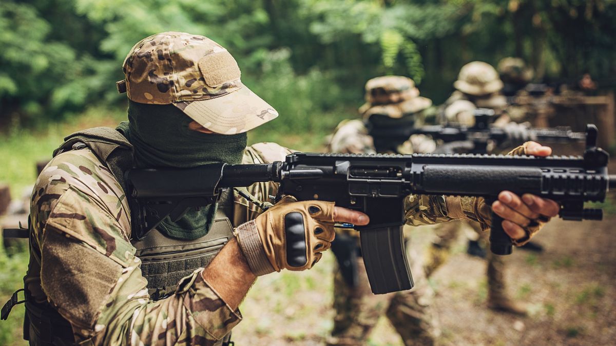 Uzbrojony żołnierz celuje z karabinu w cel podczas ćwiczeń