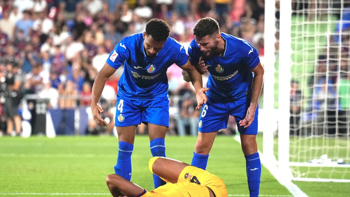 FC Barcelona defender Ronald Araujo (C) lays on the pitch in front of Gaston Alvarez (L) and Domindos Duarte (R) of Getafe during the LaLiga soccer match between Getafe and FC Barcelona at the Coliseum Alfonso Perez in Getafe, Madrid province, central Spain, 13 August 2023. EPA/Borja Sanchez-Trillo Dostawca: PAP/EPA.