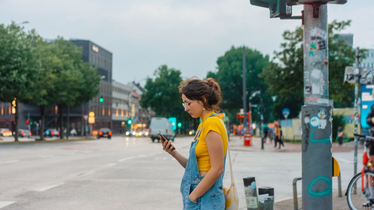 Woman using smartphone standing on pedestrian crossing
Woman in denim outfit and yellow t-shirt using smartphone while waiting for green light on pedestrian crossing
Oleh_Slobodeniuk