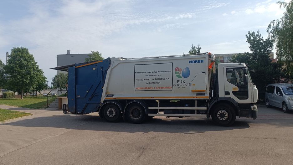 Pracownicy spółki miejskiej opróżniają altankę śmietnikową