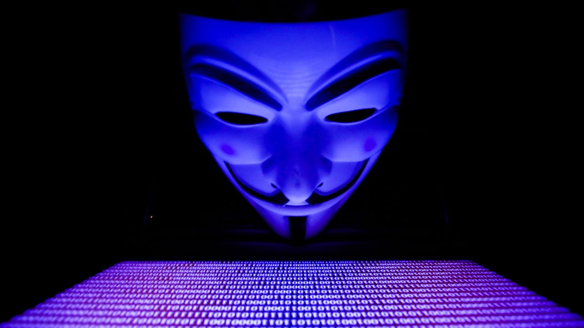 Binary code displayed on a laptop screen and Guy Fawkes mask are seen in this illustration photo taken in Krakow, Poland on March 1, 2022. Global hacker group Anonymous declared 'cyber war' against Russia. (Photo by Jakub Porzycki/NurPhoto via Getty Images)