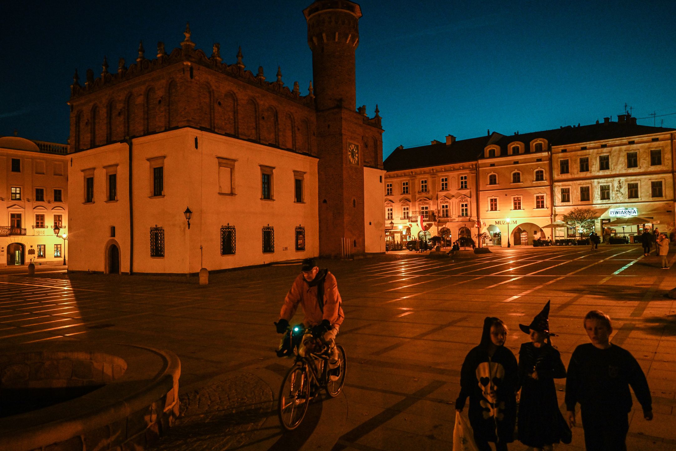 TARNOW, POLAND - OCTOBER 31 : People walk on a pedestrian street with street lamps at the old town on October 31, 2022 in Tarnow, Poland. With winter arriving in the following months and the increase of energy prices due to the Russian war on Ukraine, city authorities of the southern Polish city, Tarnow, have decided to replace more than 700 Old bulbs from the street lamps with LED ones. City authorities estimate that the installation of modern LED lighting will save about 150 MWh per year. It was also observed, that several illumination points in the old town are turned off or every second light of a lamp post is turned off. (Photo by Omar Marques/Anadolu Agency via Getty Images)
