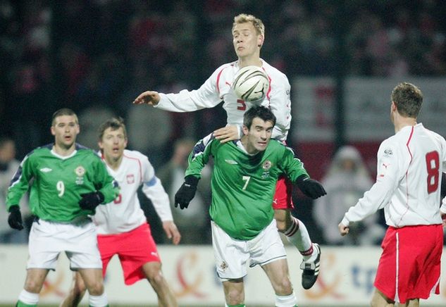 Reprezentant Irlandii Północnej podczas meczu z Polską w 2005 roku. Nad nim - Tomasz Rząsa (fot. newspix.pl)