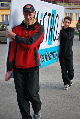 Chcesz pojechać w zawodach? To najpierw pomóż je zorganizować! Na zdjęciu Rudi Baniari (exrider, dziś w teamie Vaculika) i Martin Malek (pierwszy, historyczny kapitan drużyny) noszą banery reklamowe.