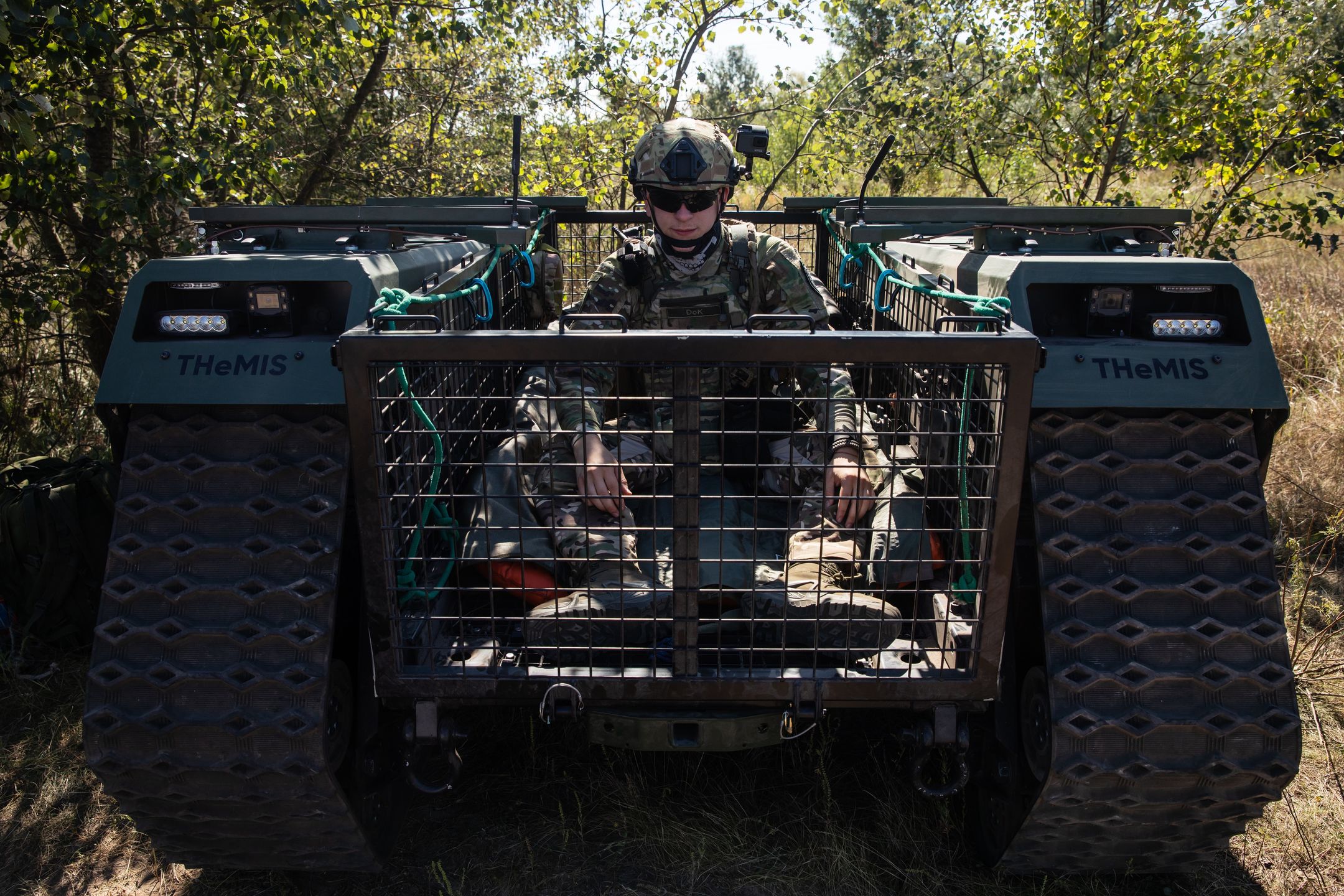 KYIV, UKRAINE - 2022/09/08: A military doctor from the group of field doctors Hospitallers moves on an unmanned ground vehicle for a wounded soldier of the armed forces of Ukraine. Field tests of THeMIS multi-purpose crawler unmanned ground vehicle of the Estonian company Milrem Robotics which will be used for evacuation purpose on the frontline of wounded soldiers by Medical battalion "Hospitallers". The evacuation robot "Zhuravel" passed the first test. The robot will be used on the front line, in those places where it is difficult for medics to reach by vehicle or on foot. (Photo by Mykhaylo Palinchak/SOPA Images/LightRocket via Getty Images)