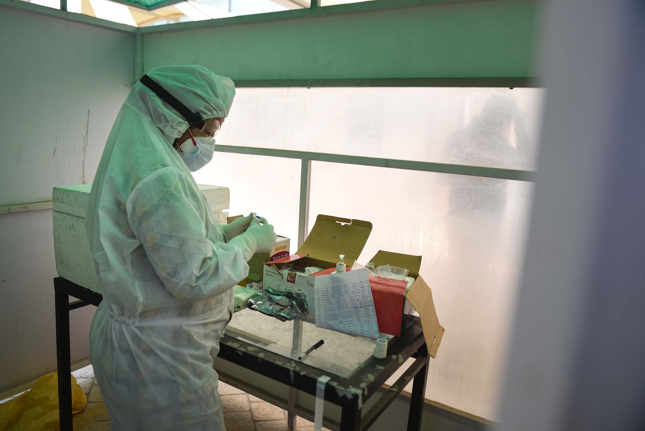 NEW DELHI, INDIA - JUNE 16: A medical worker wearing PPE coveralls collects a swab sample from a patient to test for COVID-19 infection, at a testing centre, in Karkardooma on June 16, 2020 in New Delhi, India. (Photo by Sanchit Khanna/Hindustan Times via Getty Images)