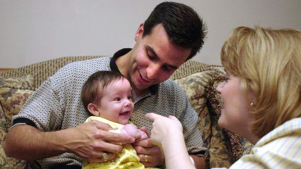 Dziecko ze zdjęcie ''Hand of Hope'' z rodzicami [http://specials.myajc.com]