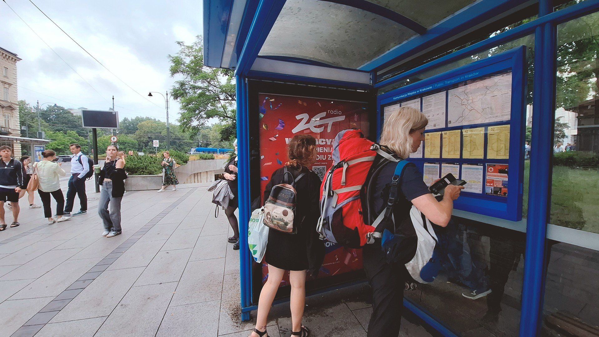 Przystanek tramwajowo-autobusowy &#34;Teatr Słowackiego 01&#34; w Krakowie. Pod jedną wiatą tramwaj i autobus, pod drugą – rozkłady jazdy. Zarząd Transportu Publicznego w Krakowie obiecał przyjrzeć się sytuacji.