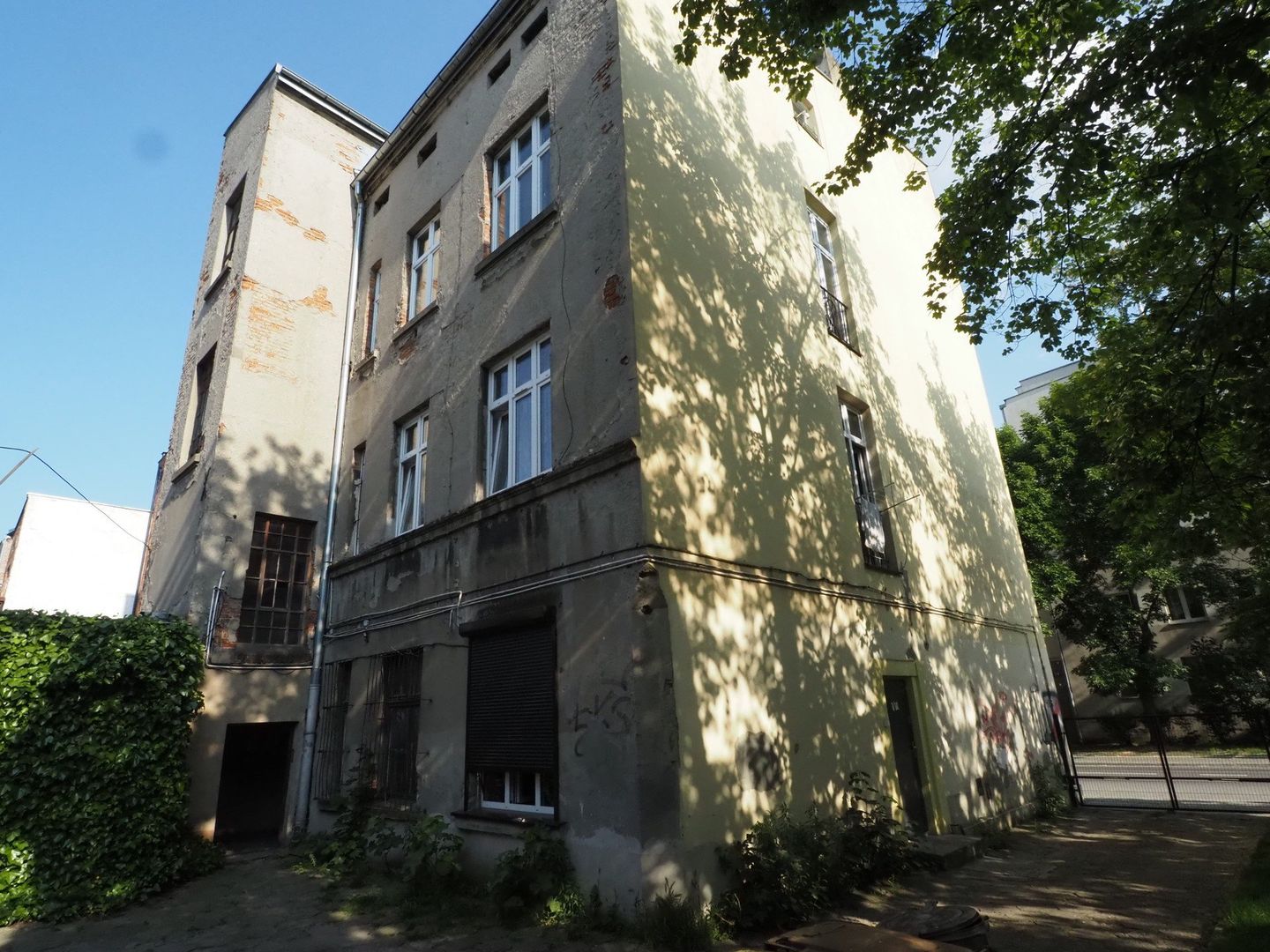 Pan Tomasz Spodenkiewicz pokazuje pisma jakie dostał od PINB. W tle jego kamienica i okoliczne, pod którymi także będzie przechodził tunel CPK