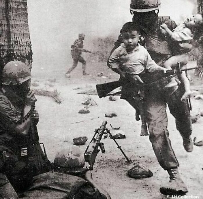 Amerykański żołnierz ratujący dzieci podczas strzelaniny na froncie w Wietnamie. 1968.