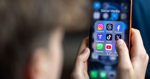 BATH, UNITED KINGDOM - MARCH 29: In this photo illustration a 14-year-old boy holds an iPhone screen displaying various social media and messaging apps on March 29, 2026 in Bath, England. On top row left to right, the logo of social media platform Instagram is seen beside that of Meta’s Threads and Facebook. On the middle row from left is the logo of Donald Trump's Truth Social app, next to the logo of social media app TikTok and the logo of Elon Musk’s US online social media and social networking site 'X' (formerly known as Twitter). Along the bottom row, left to right is the messaging service WhatsApp, the logo for online video sharing and social media platform YouTube and the logo for the Bluesky app. In the UK, a ban on social media for under-16s has been backed by the House of Lords following the Australian law which aims to stop children under 16 from having social media accounts and social media platforms, including TikTok, Facebook, Snapchat, Reddit, X, formerly Twitter, and Instagram potentially being be fined for preventing children younger than 16 from having social media accounts. (Photo by Anna Barclay/Getty Images)