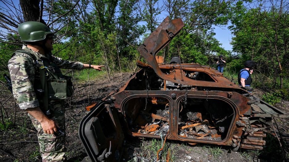 DONETSK REGION, UKRAINE - MAY 31, 2022 - A Ukrainian serviceman points at a destroyed Russian BMP-2 infantry fighting vehicle by the roadside between Zelene Pole and Novopil villages, Donetsk Region, eastern Ukraine. This photo cannot be distributed in the Russian Federation. (Photo credit should read Dmytro Smolyenko/ Ukrinform/Future Publishing via Getty Images)