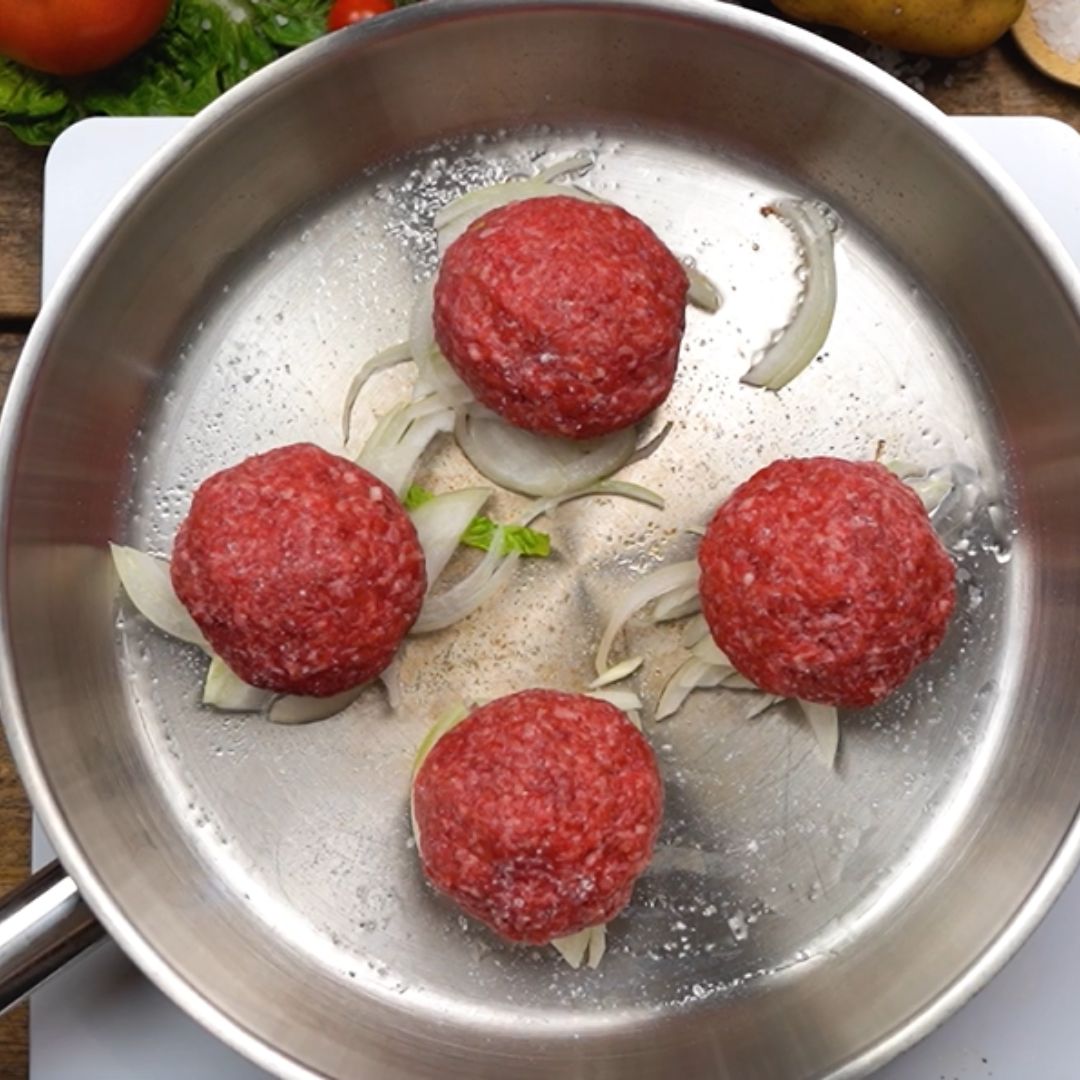 The meat, along with the add-ons, goes into the pan.