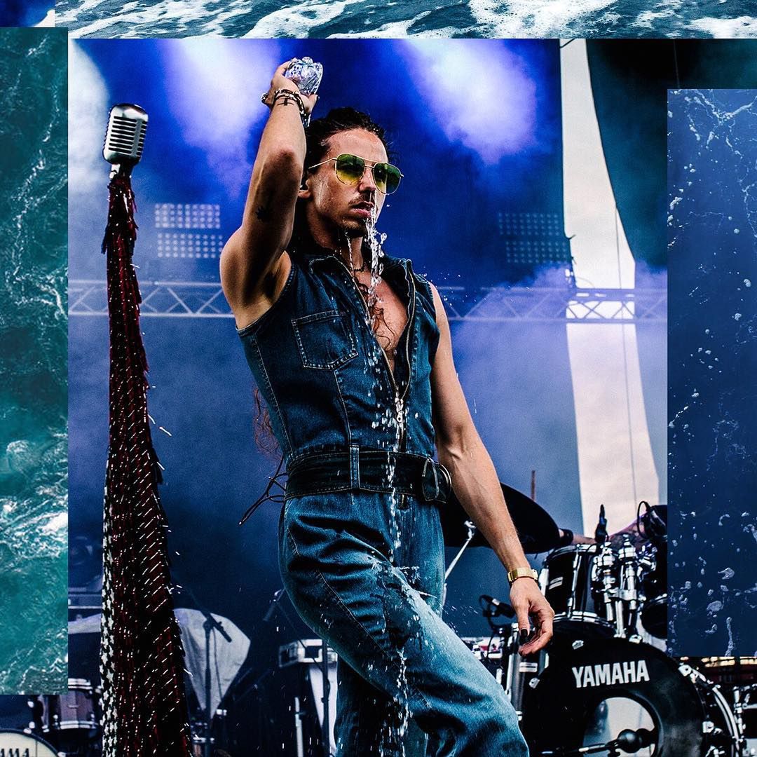 Michał Szpak oblewa się wodą podczas koncertu