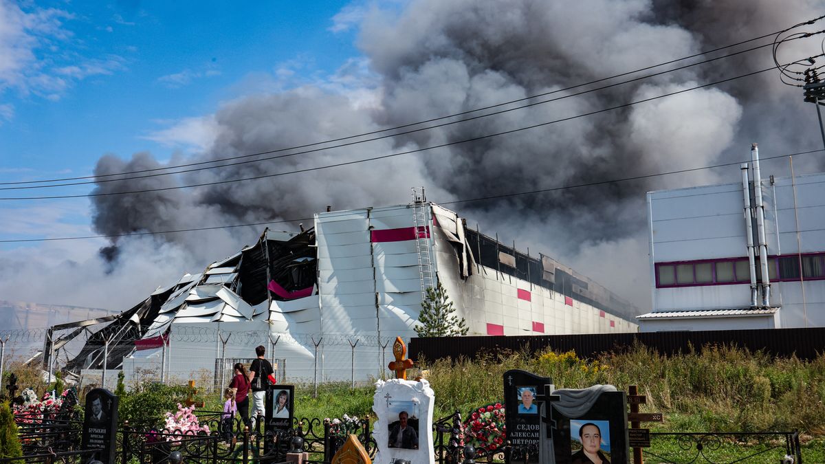 People walk among graves at a cemetery as smoke rises above a Wildberries facility (back) following a reported Ukrainian drone strike at the Koledino Industrial Park near Podolsk, Moscow Region, Russia, 16 August 2026. Moscow Region Governor Andrei Vorobyov reported that an overnight drone attack ignited a major fire at a warehouse belonging to Russia's largest online retailer Wildberries, adding that no employees were injured at the site. EPA/STRINGER Dostawca: PAP/EPA.