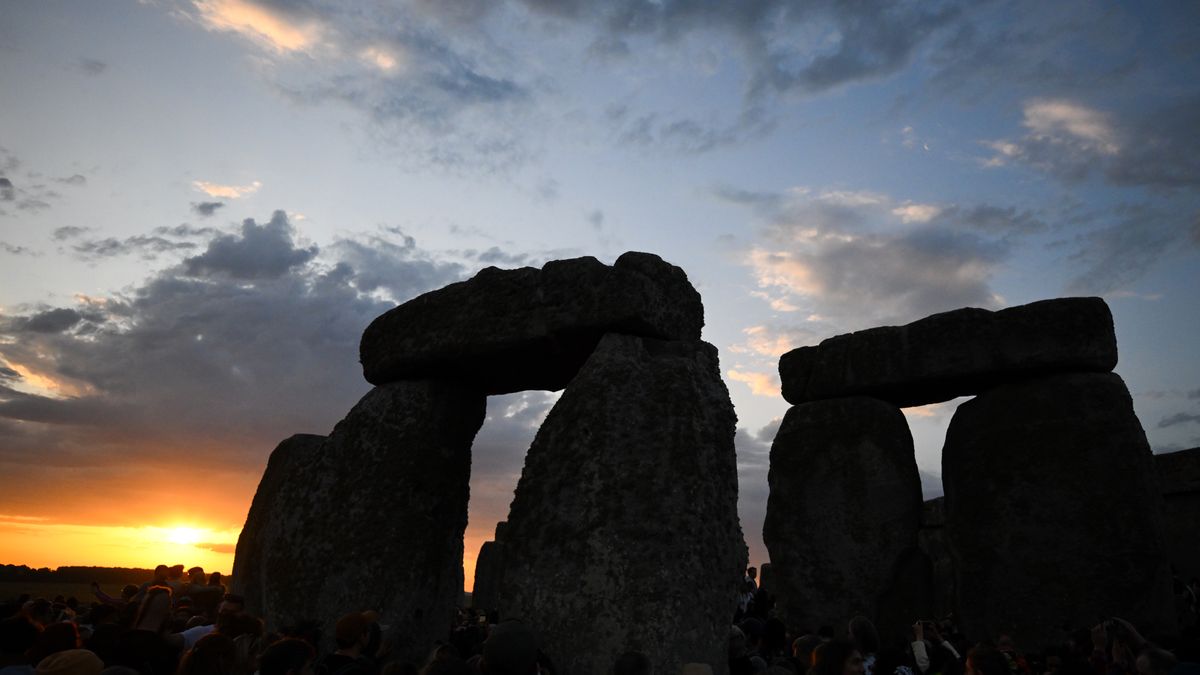 WILTSHIRE, ENGLAND - JUNE 21: Visitors enjoy the sunrise during celebrations of the summer solstice at Stonehenge, on June 21, 2025 in Wiltshire, England. On the longest day of the year in the Northern Hemisphere, the sun rises in perfect alignment with the Heel Stone and Altar Stone of Stonehenge's 5000-year-old circle. This alignment shows the ancient builders' understanding of the solar calendar and suggests Stonehenge may have served as a calendar or temple for important dates and events - a tradition that continues to be marked each year. (Photo by Finnbarr Webster/Getty Images)