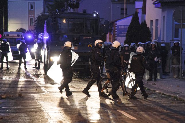 Lubin, 08.08.2021. Policja podczas protestu przed Komendą Powiatową Policji na ul. Traugutta w Lubinie, 8 bm. W piątek 6 bm. policjanci interweniowali w sprawie mężczyzny, który miał być pod wpływem narkotyków i rzucać w okna mieszkańców kamieniami. Policjanci po przybyciu go obezwładnili. Protestujący uważają że mężczyzna zmarł podczas interwencji. (aldg) PAP/Aleksander Koźmiński