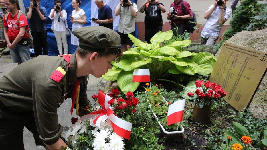 Dzieci sprzątają groby powstańców, którzy zginęli w Powstaniu Warszawskim