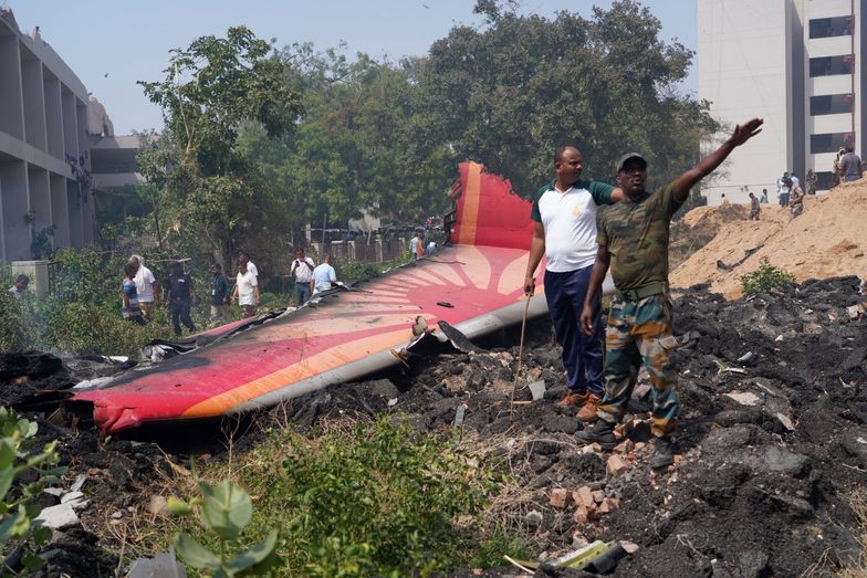 People stand near debris at the site of a plane crash near Sardar Vallabhbhai Patel International Airport in Ahmedabad, Gujarat, western India, 12 June 2025. Air India flight AI171, bound for London carrying 242 passengers and crew members on board a Boeing 787-8 aircraft, crashed minutes after take-off in the Meghaninagar area of Ahmedabad. EPA/SIDDHARAJ SOLANKI Dostawca: PAP/EPA.