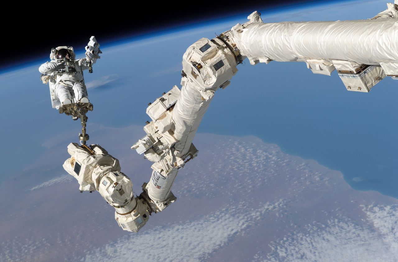 Astronauta przymocowany do końca ramienia Canadarm2