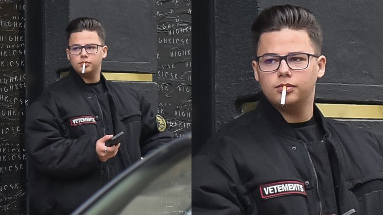 Allan Krupa pali papierosa przed butikiem