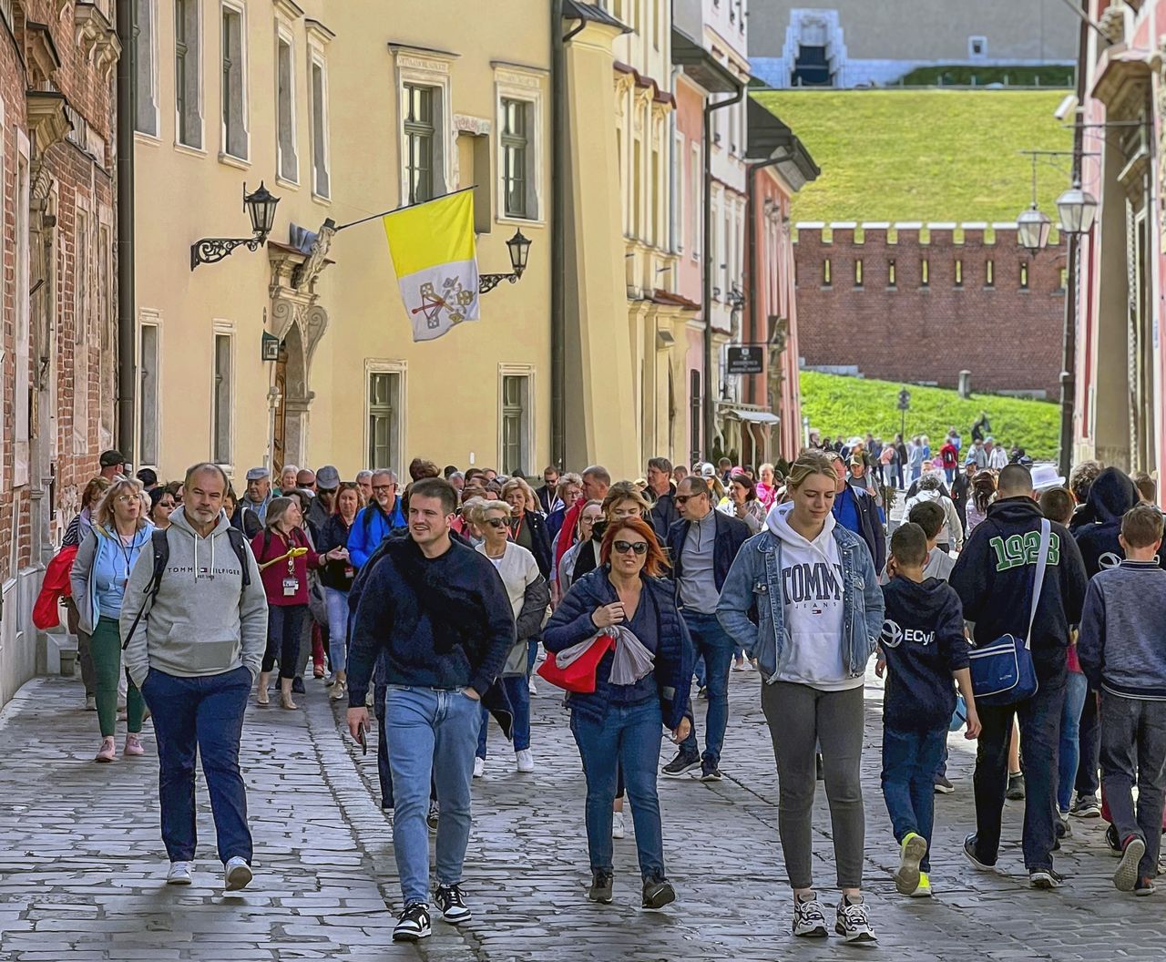 Grupa turystów zwiedzająca miasto, ulica Kanonicza u stóp wzgórza wawelskiego