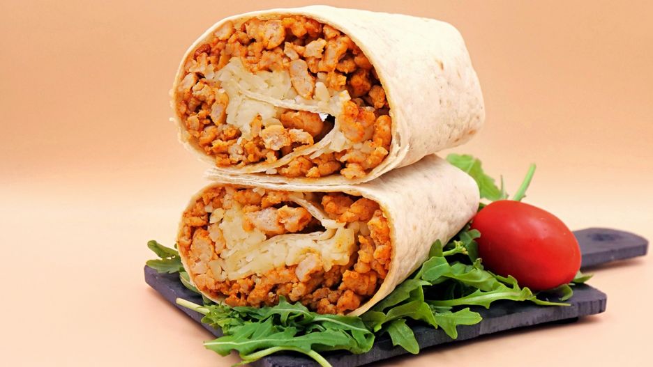 Przekładam gotowe burrito z kurczakiem na talerz.