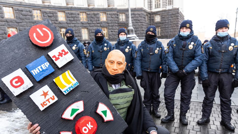 A protester with a Wladimir Putin mask protests against usage of Russian language in Ukrainian TV in front of the main governmental building secured by a police unit  on February 1, 2022 in Kiev, Ukraine. Protests arise amid rising tension with Russia as Russia massed more than 100 thousand soldiers at the Ukrainian border and the West fears Ukraine might be invaded. (Photo by Dominika Zarzycka/NurPhoto via Getty Images)