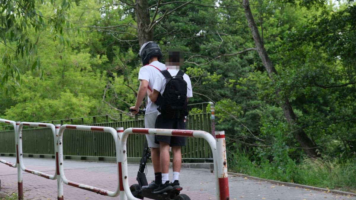 Dwie osoby jadące na hulajnodze