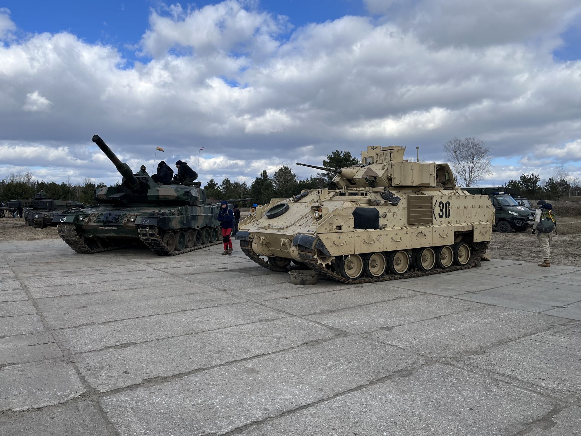 Wóz opancerzony Bradley, na drugim planie - Leopard
