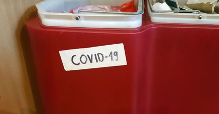 Koronawirus w Polsce. Zawiercie. Napisy COVID-19 na koszach na śmieci przed domami chorych