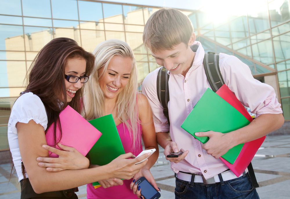 Image of a three young people looking at the cellphones