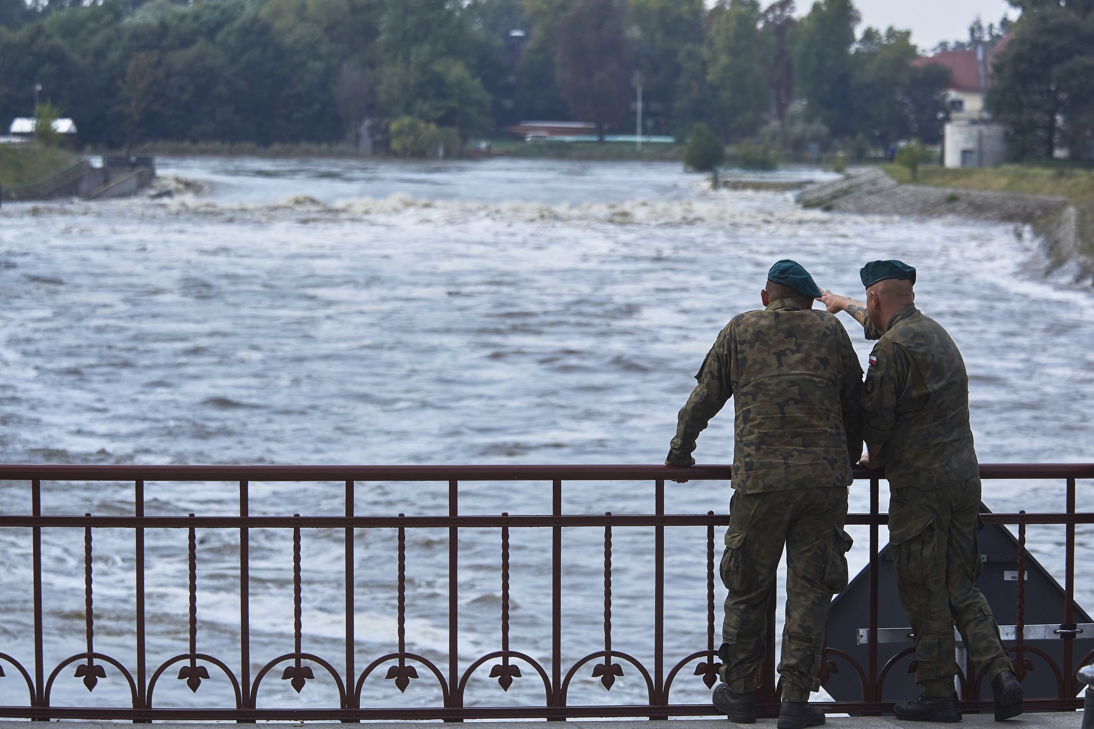 Polish soldiers look at the high water level on the Oder River in central Wroclaw, Poland, on Thursday, Sept. 19, 2024. The Polish and Czech economies will take a knock and government coffers are going to get more stretched all while ministers try to move quickly to demonstrate they are on top of the crisis. Photographer: Bartek Sadowski/Bloomberg via Getty Images