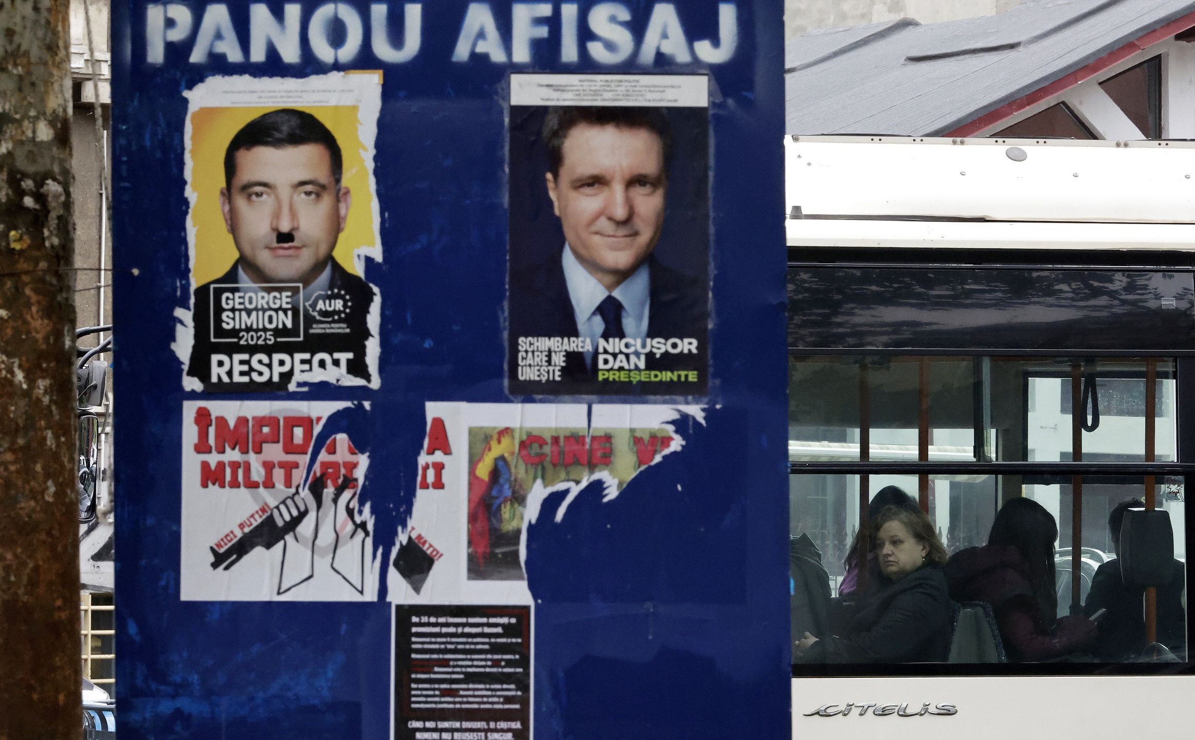 A woman looks out from a bus as it passes a billboard displaying electoral posters of the candidates for the runoff of the 2025 presidential election, in Bucharest, Romania, 16 May 2025. The runoff for the 2025 Romanian presidential election will be held on 18 May between AUR party leader George Simion, who won the first round of the Romanian election rerun with 40.96 percent of the vote, and mayor of Bucharest Nicusor Dan. EPA/ROBERT GHEMENT Dostawca: PAP/EPA.
