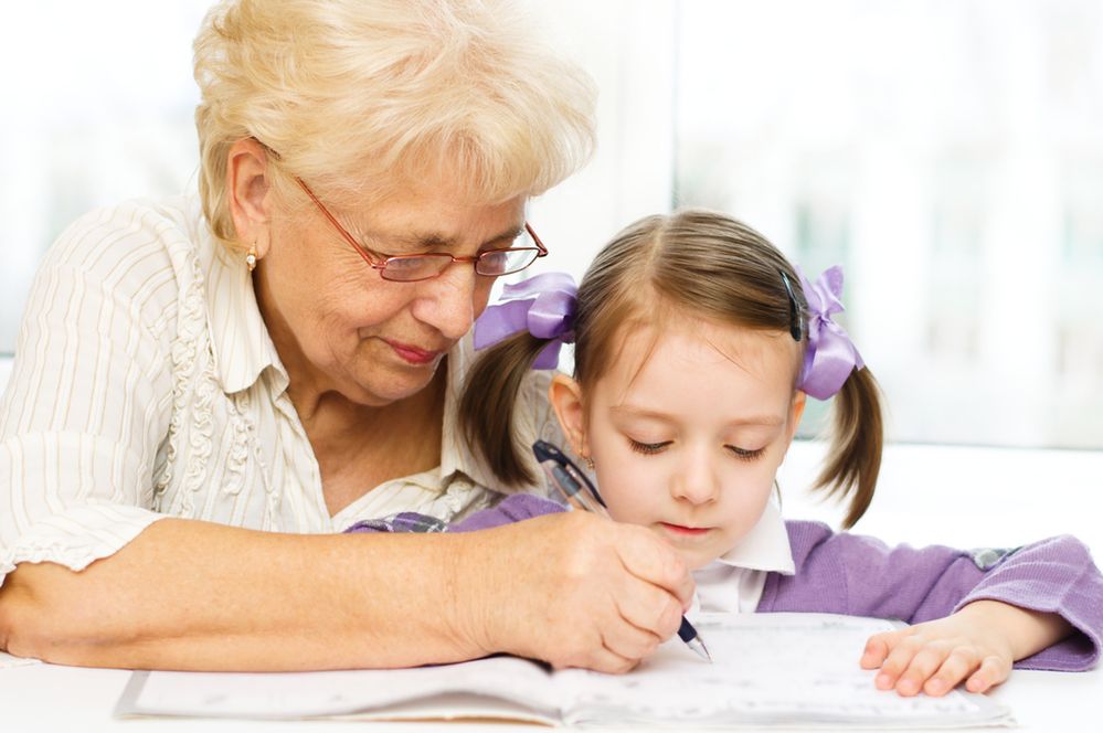 Zdjęcie babci uczącej wnuczkę pisania pochodzi z serwisu Shutterstock