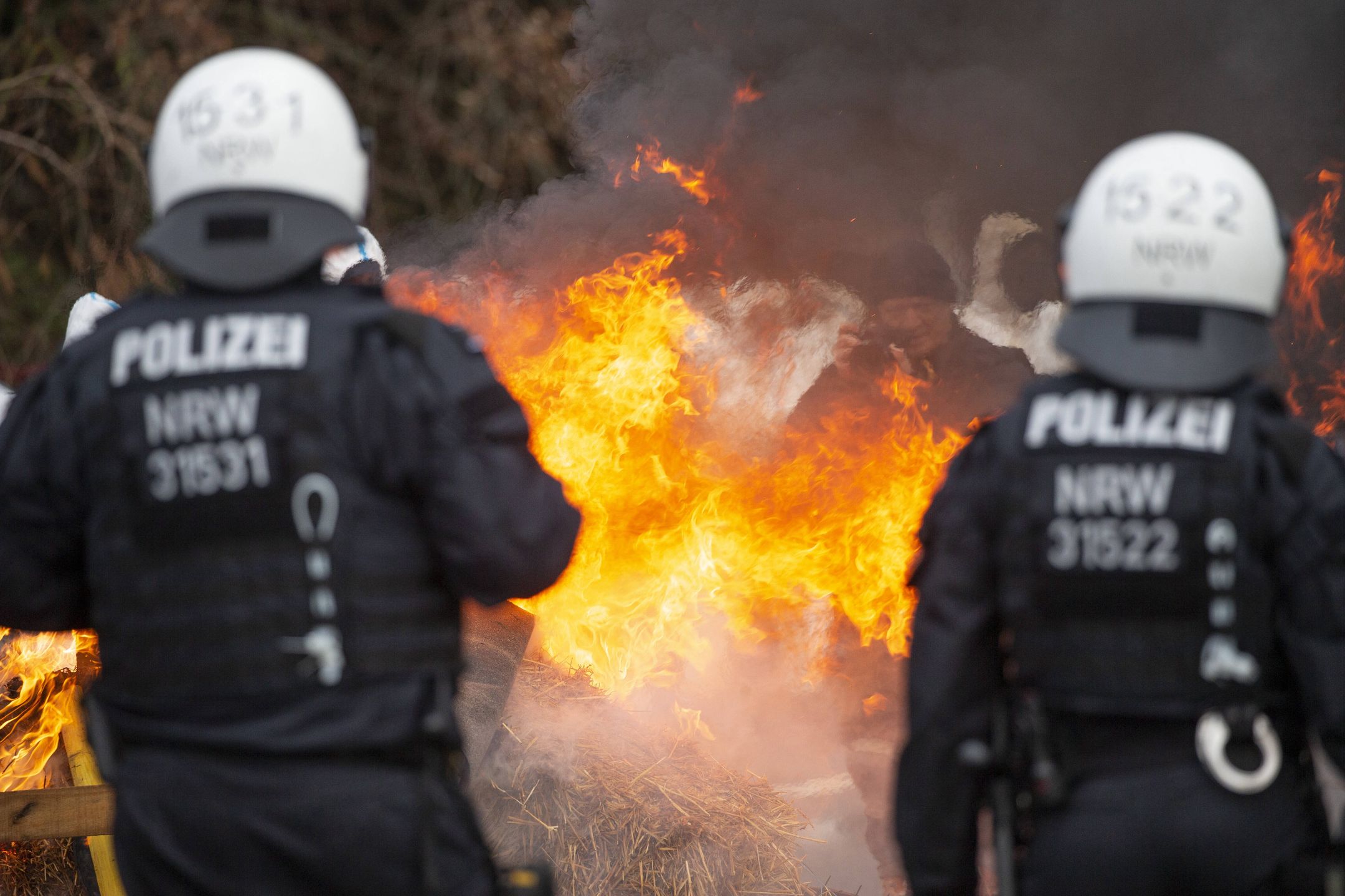 Activists block road to Luetzerath village set to be demolished
02 January 2023, North Rhine-Westphalia, Luetzerath: Police officers stand behind a burning straw bales set on fire by activists  near the site of the planned evacuation of the village of Luetzerath. German climate activists positioned themselves on Monday behind a burning barricade to stop construction workers reaching a village earmarked for demolition for mining works. Photo: Thomas Banneyer/dpa 
Dostawca: PAP/DPA.
Thomas Banneyer
