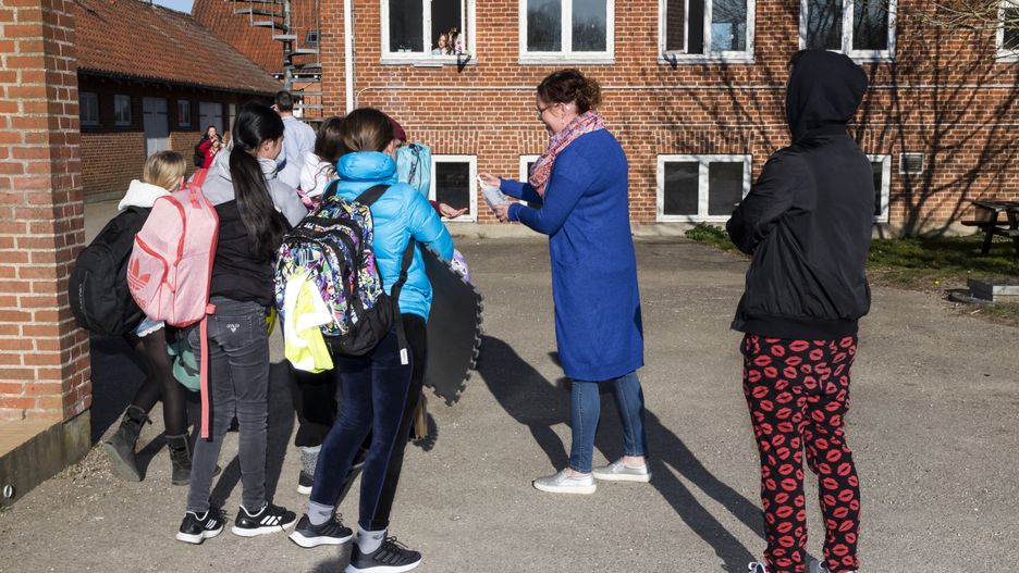 RINGSTED, DENMARK - APRIL 20: School teacher Louise Sjoestein (C) at Ringsted Lilleskole gives out hand sanitizer as pupils are welcomed back to school after closing for five weeks due to the coronavirus outbreak on April 20, 2020, in Ringsted, Denmark. Only pupils up to 5th grade are currently permitted to return to school as Denmark begins to ease restrictions, and higher grades must stay at home. The children must apply to strict rules regarding social distance and hygiene. (Photo by Ole Jensen/Getty Images)