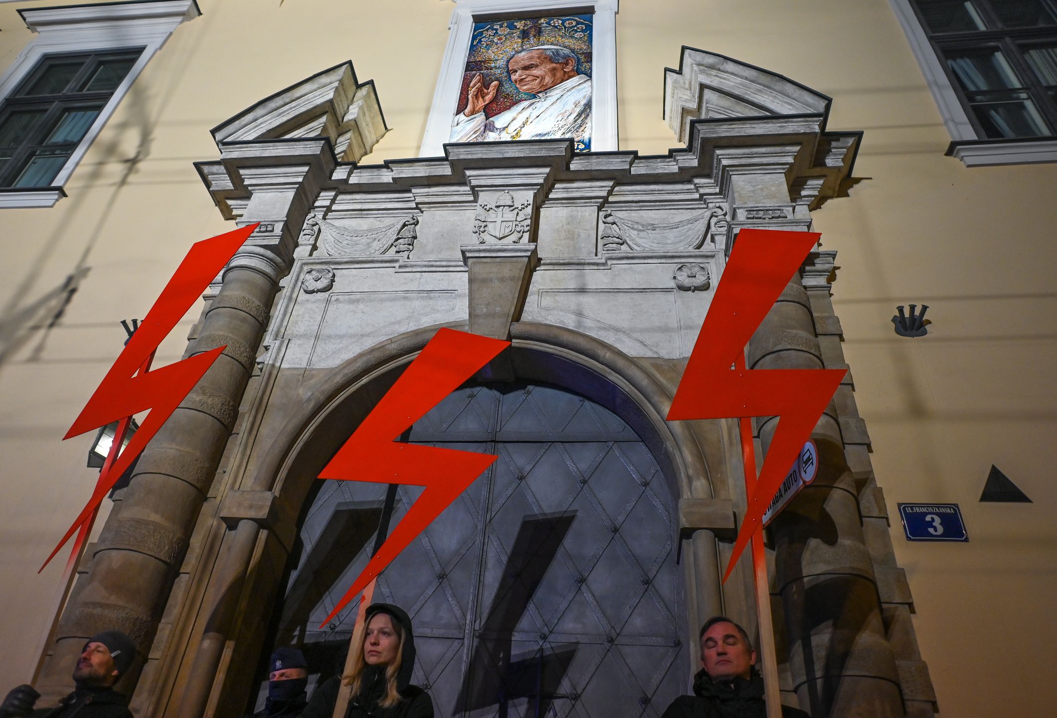 Women's Rights Protest Held In KrakowActivists hold three red lightning bolts, the main symbol of the pro-choice movement, outside the 'Papal Window' of of the Bishop's Palace during the 'Our Struggle Still Continues' protest in Krakow, on the 104th anniversary of obtaining voting rights by Polish women. Poland was one of the first countries to grant rights to women: women's suffrage was passed on November 28, 1918, after the country regained its independence that year, after 123 years of partitions and foreign rule. In Poland 2022, women still have a lot to fight for: the right to decide about their lives and health without the interference of the church hierarchy and politicians, the right to legal abortion and respect for the LGBTQ+ community.On Monday, November 28, 2022, in Krakow, Lesser Poland Voivodeship, Poland. (Photo by Artur Widak/NurPhoto via Getty Images)NurPhotoblack protest, church rules, polish church, step back, women rights, women vote, activists, anti-goverment, expression, right to vote, women's suffrage, pro-choice movement, polish women, suffrage, right to decide lives and health