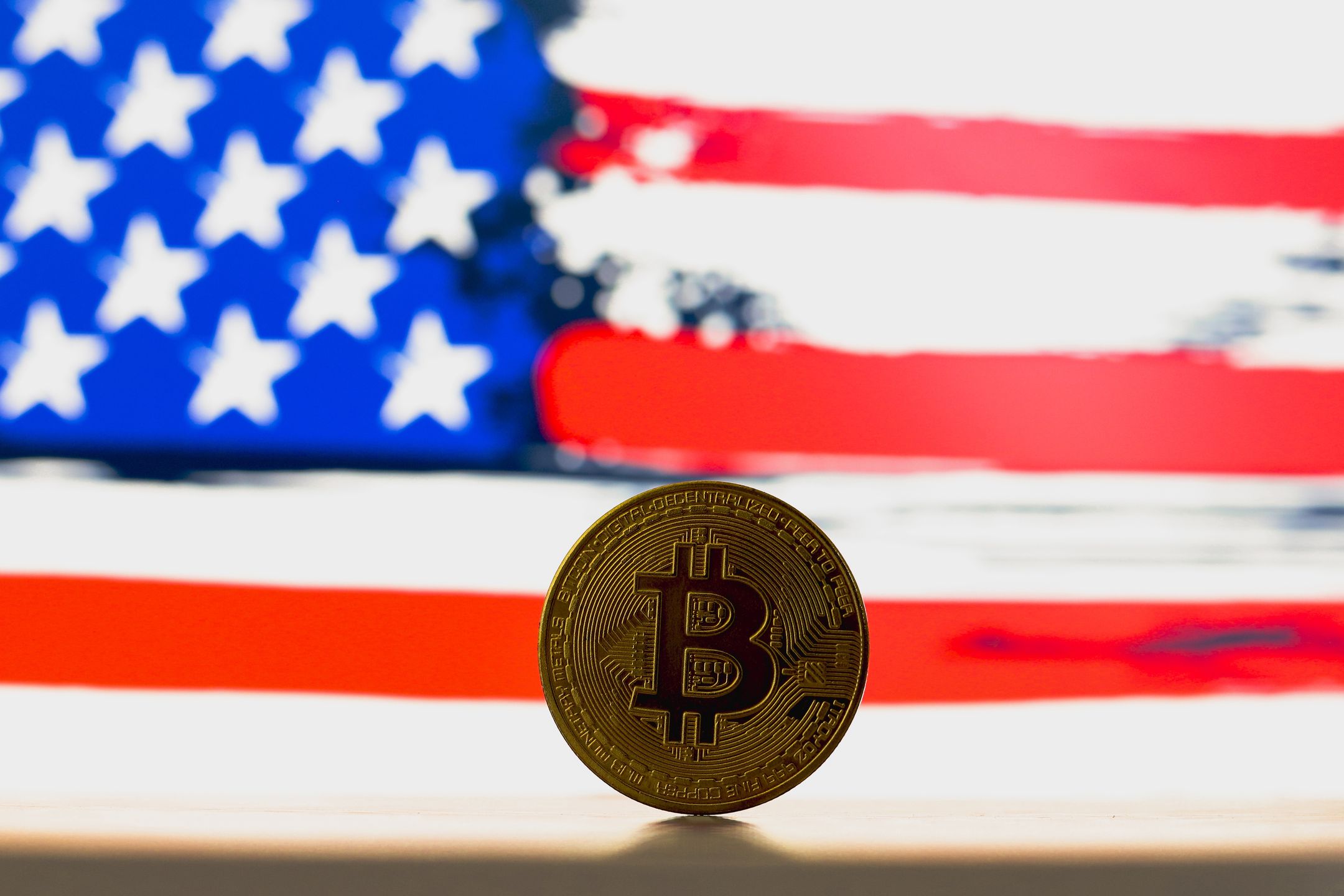 PARAGUAY - 2024/07/03: In this photo illustration, a Bitcoin is seen on the table and the United States flag in the background. (Photo Illustration by Jaque Silva/SOPA Images/LightRocket via Getty Images)