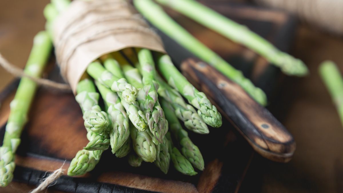 Pęczek szparagów na drewnianej desce do krojenia