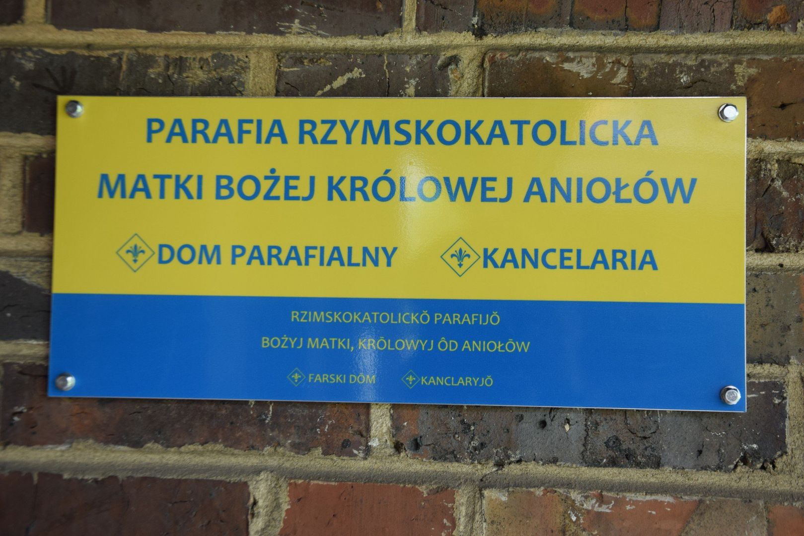 Tablice informacyjne po polsku i po śląsku przy kościele MB Królowej Aniołów w Wilkowyjach