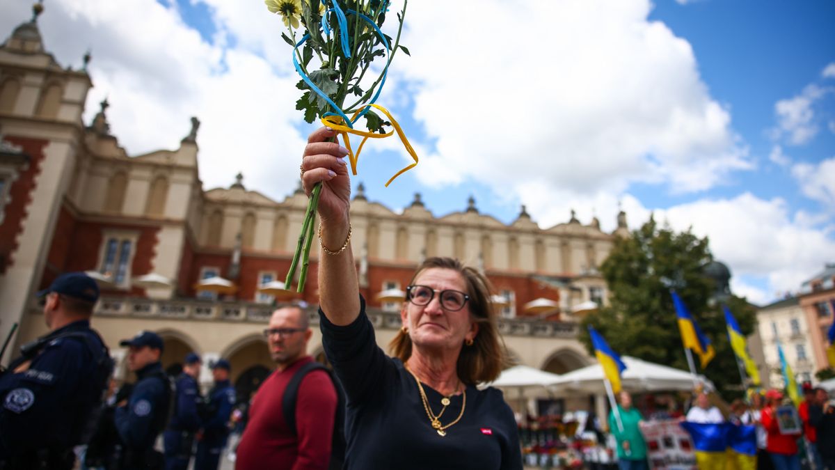 A woman holds flowers in Ukrainian flag colours while attending a gathering on the Independence Day of Ukraine in Krakow, Poland on August 24, 2025. (Photo by Beata Zawrzel/NurPhoto via Getty Images)