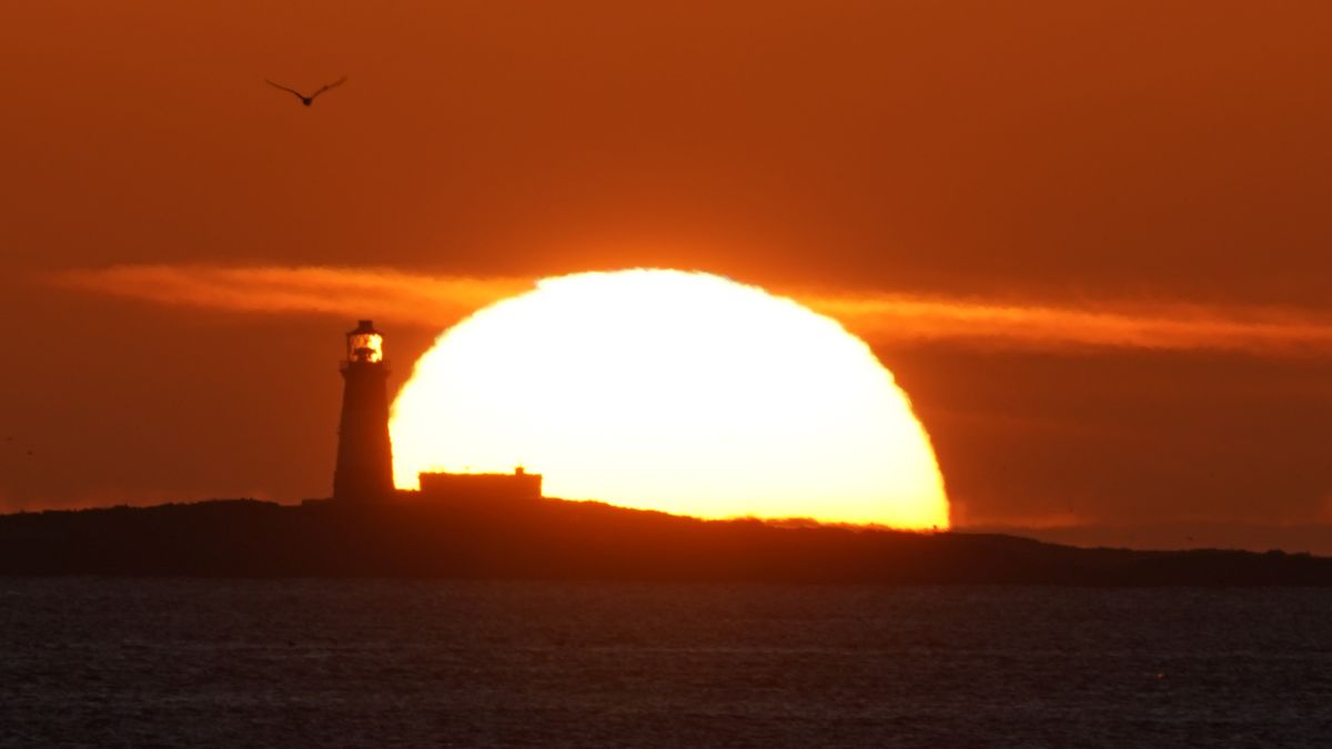 The sun rises over the 19th century Longstone Lighthouse located on Longstone Rock in the outer group of the Farne Islands off the coast of Northumberland. The UK will see sunshine and showers after a mix of intense heat and torrential rain in recent weeks. Picture date: Friday August 19, 2022. (Photo by Owen Humphreys/PA Images via Getty Images)