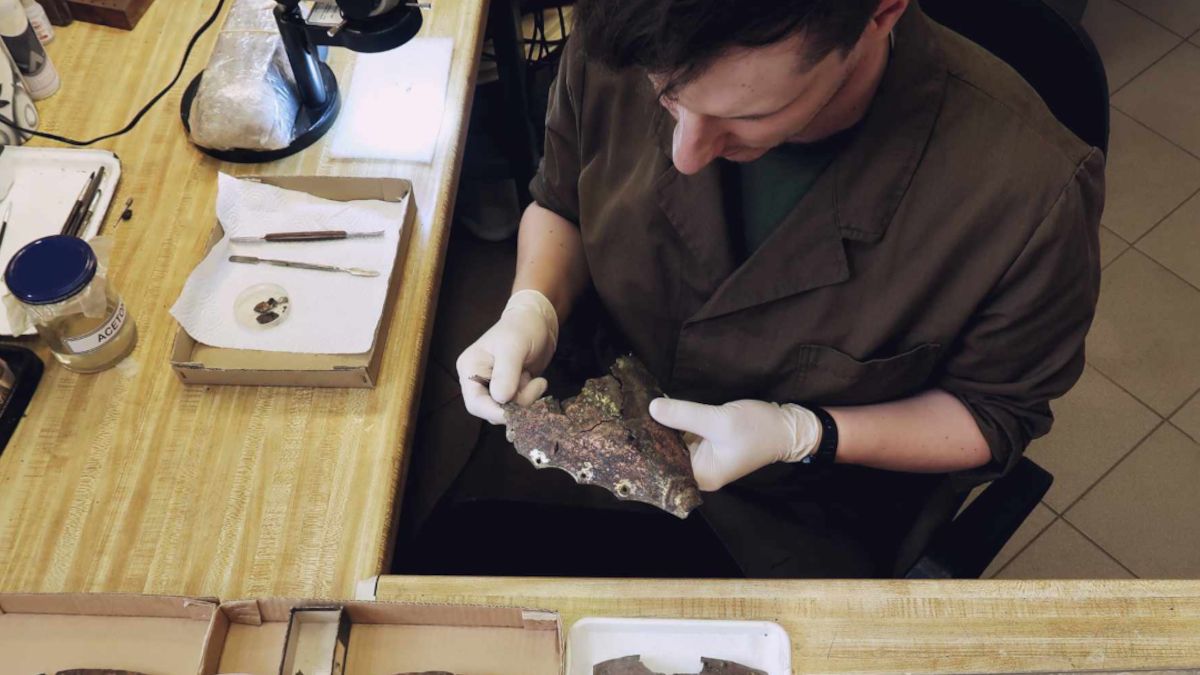 Mikołaj Organek podczas prac konserwatorskich nad hełmem.