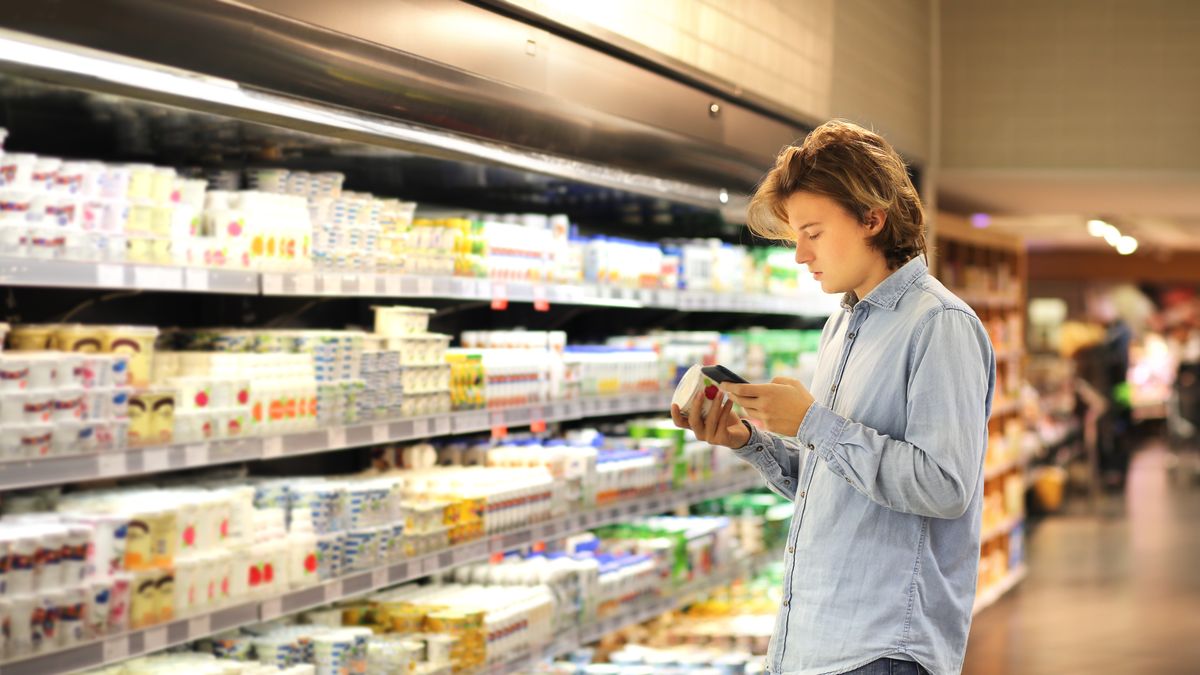 adult, buying, cheese, choice, choosing, comparison, consumerism, cottage cheese, customer, dairy products, decisions, food, freshness, frozen, groceries, grocery store, healthy, holding, kefir, label, lifestyle, looking, male, mall, man, market, marketplace, men, merchandise, milk, oil, people, price, reading, refrigerator, retail, sale, sausage, sausages, shop, shopping, shopping basket, sour cream, store, supermarket, teen, teenager, uncertainty, yogurt, young